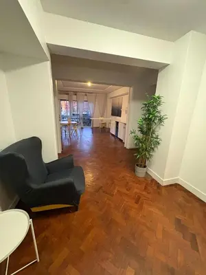 a living room with a black couch and a wooden floor at Hotel Europe in Ljubljana