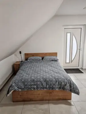 a bedroom with a bed with a wooden frame at Apartma pod Tremi Kralji in Oplotnica