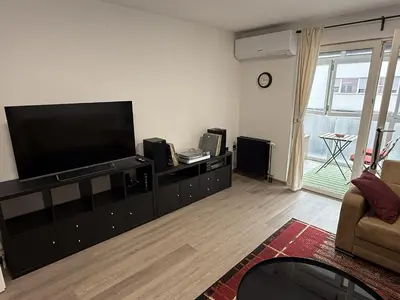 a living room with a flat screen tv on a entertainment center at Mary's flat in Ljubljana