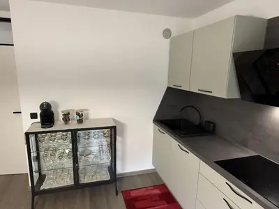 a kitchen with white cabinets and a glass case at Mary's flat in Ljubljana