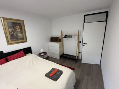 a bedroom with a white bed and a white closet at Mary's flat in Ljubljana