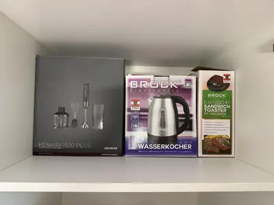 a shelf with three boxes and a tea kettle at Mary's flat in Ljubljana