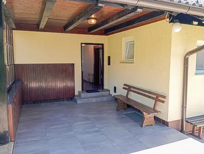 a porch with a wooden bench and a building at Vineyard cottage Tilka in Novo Mesto