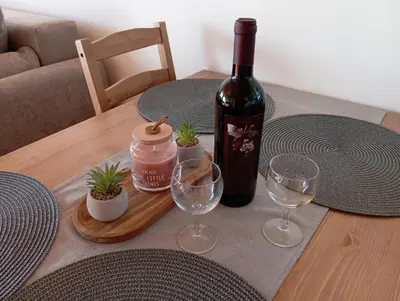 a bottle of wine sitting on a table with wine glasses at Vineyard cottage Tilka in Novo Mesto