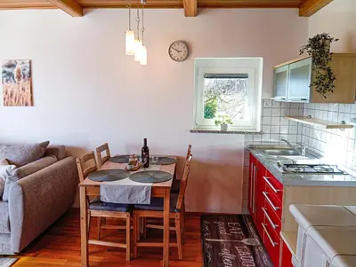 a small kitchen with a table and a couch at Vineyard cottage Tilka in Novo Mesto