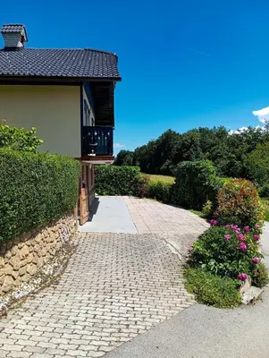 a house with a brick walkway next to a building at Vineyard cottage Tilka in Novo Mesto
