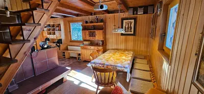 a small room with a table and a kitchen at Holiday cottage Pod Smreko in Cerklje na Gorenjskem