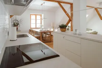 a kitchen with white cabinets and a dining room at Apartmaji Matec in Fala