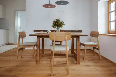 a dining room table with chairs and a vase of flowers at Apartmaji Matec in Fala