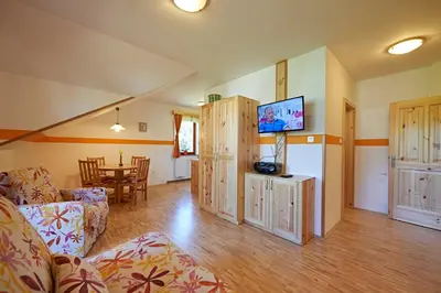a living room with a couch and a tv and a table at Farm Stay Gradišnik Peaceful Countryside with Homemade Breakfast in Prevalje
