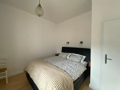 a bedroom with a bed in a white room at Vila Marla in Hrušica