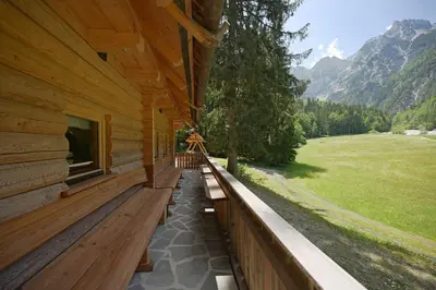 a porch of a log cabin with a bench on it at Alpine Loghouse Planšarska bajta Matkov Kot in Solčava
