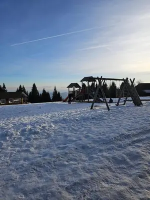 an empty playground in a snow covered field at Cosy Rogla appartment 108 in Zreče