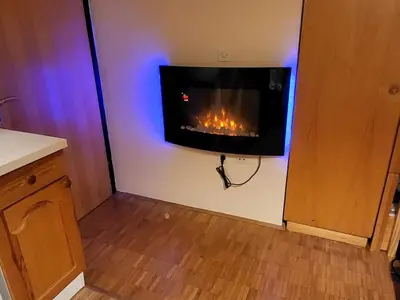 a living room with a fireplace on the wall at Cosy Rogla appartment 108 in Zreče