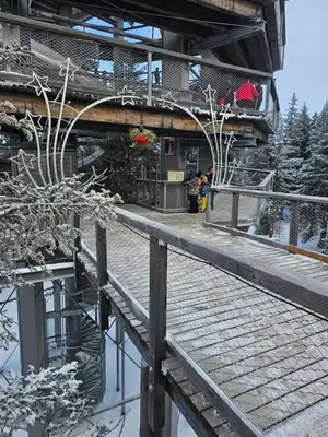 a building with a wooden walkway next to a body of water at Cosy Rogla appartment 108 in Zreče