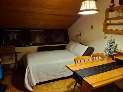 a bedroom with a bed and a christmas tree in it at Cosy Rogla appartment 108 in Zreče