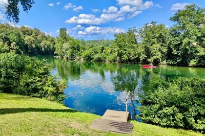 a boat on a river with a red boat at VRBA Premium riverside mobile house BIG BERRY in Gradac