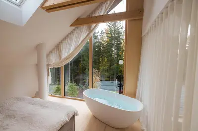 a bathroom with a large tub in front of a window at Lanina Chalet Luxury Mountain Escape in Pohorje