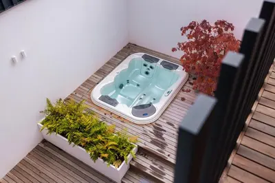 a bath tub sitting on a balcony with plants at Lanina Chalet Luxury Mountain Escape in Pohorje