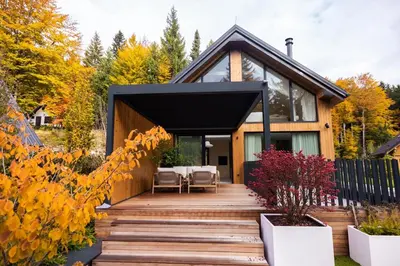 a house with a wooden deck in the yard at Lanina Chalet Luxury Mountain Escape in Pohorje