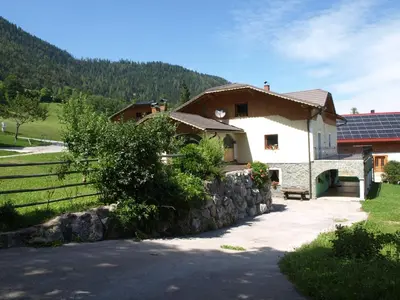 a house with a stone wall next to a building at Apartma Spodnji Goltnik 1 in Mozirje