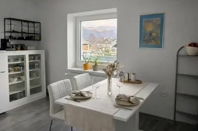 a white dining room with a table and a window at Apartment Čebelica in Lesce