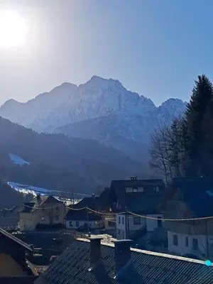 a mountain in the background of a town with houses at Apartma Pirc in Kranjska Gora