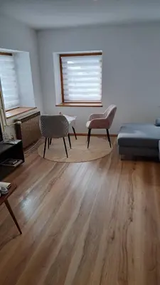 a living room with a bed and two chairs at Apartma Pirc in Kranjska Gora