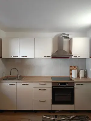 a kitchen with white cabinets and a stove top oven at Apartma Pirc in Kranjska Gora