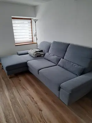 a blue couch in a living room with a window at Apartma Pirc in Kranjska Gora
