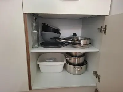 a cupboard with pots and pans in a kitchen at Cosy central apartment in Litija