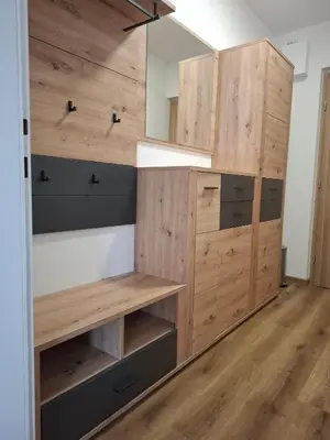 a closet with wooden cabinets and a mirror at Cosy central apartment in Litija