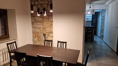 a dining room with a wooden table and chairs at Mark & Lana in Sežana