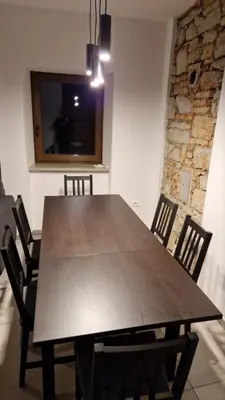 a dining room with a wooden table and chairs at Mark & Lana in Sežana