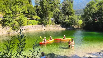 a group of people in the water in a river at Cozy wabi-sabi retreat w bikes by the river in Bohinj