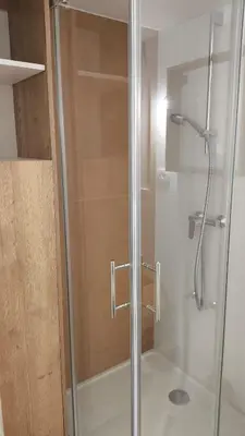 a shower with a glass door in a bathroom at Cozy wabi-sabi retreat w bikes by the river in Bohinj