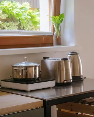 two pots and pans sitting on a counter next to a window at Cozy wabi-sabi retreat w bikes by the river in Bohinj