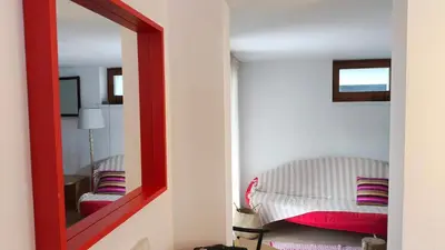 a mirror in a room with a bed and a chair at Cozy wabi-sabi retreat w bikes by the river in Bohinj