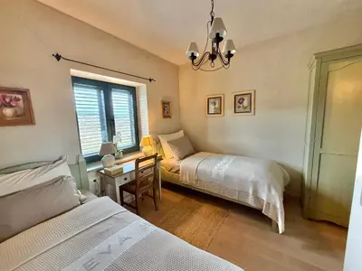 a bedroom with two beds and a desk and a window at Private Villa for 12 Peaceful Karst Escape in Dutovlje