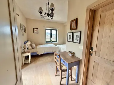 a bedroom with a bed and a table with a chair at Private Villa for 12 Peaceful Karst Escape in Dutovlje