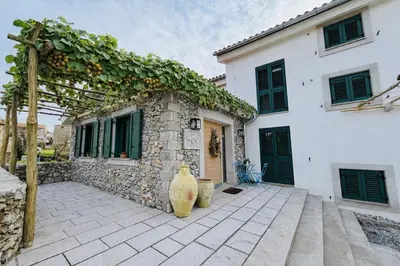 a house with two vases sitting outside of it at Private Villa for 12 Peaceful Karst Escape in Dutovlje