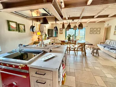 a kitchen with a counter and a dining room at Private Villa for 12 Peaceful Karst Escape in Dutovlje
