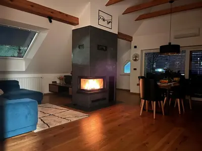 a living room with a fireplace and a dining room at Eden Superior Family Apartment near Terme Paradiso with FREE pool tickets in Dobova