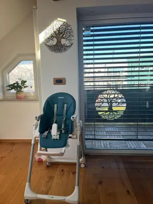 a blue rocking chair in a room with a window at Eden Superior Family Apartment near Terme Paradiso with FREE pool tickets in Dobova
