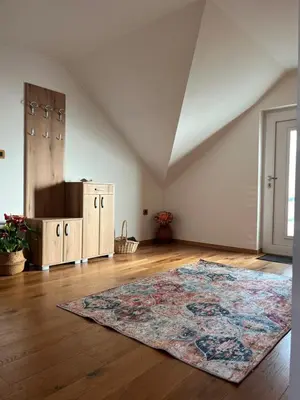 an attic room with a rug on a wooden floor at Eden Superior Family Apartment near Terme Paradiso with FREE pool tickets in Dobova