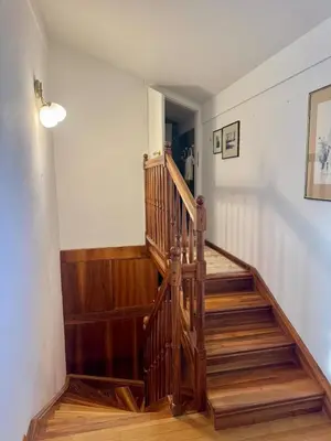 a wooden staircase in a room with a hallway at Peaceful & Spacious Villa With A Beautiful Garden in Ljubljana
