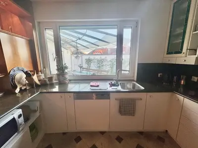 a kitchen with a dog standing in front of a window at Peaceful & Spacious Villa With A Beautiful Garden in Ljubljana