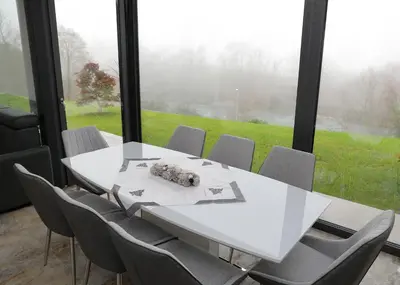 a white table and chairs in a room with a large window at Apartma Belvi in Brežice