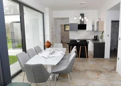 a dining room and kitchen with a white table and chairs at Apartma Belvi in Brežice