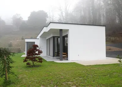 a small white house in the middle of a field at Apartma Belvi in Brežice